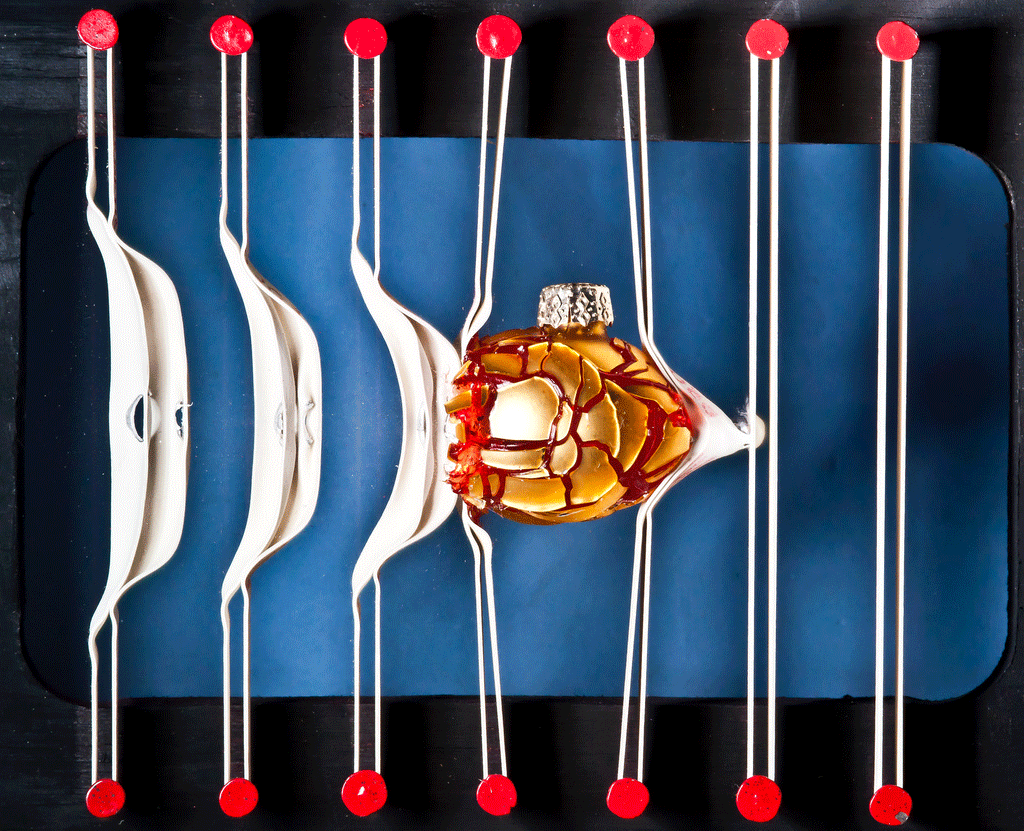 Bola dorada de navidad, entre bandas de goma Alan Sailer