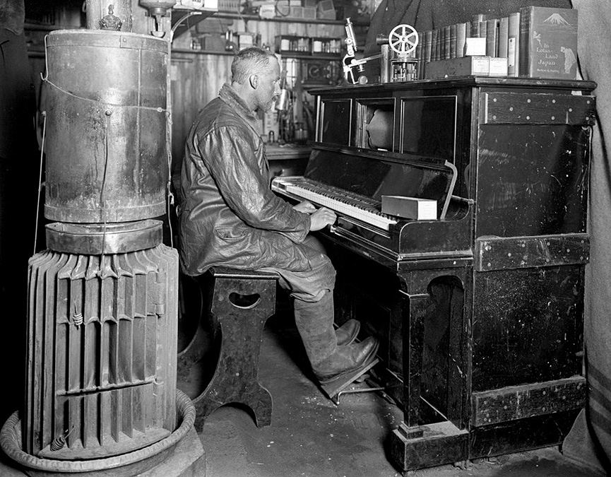 El adiestrador de perros Cecil Meares en la pianola de la cabaña de invierno, enero de 1912. Herbert Ponting