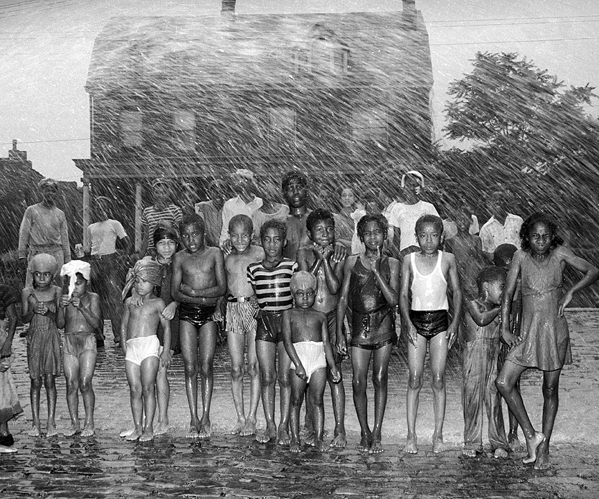 Un bombero refresca con la manguera a los jóvenes del barrio, 1947. Charles Harris