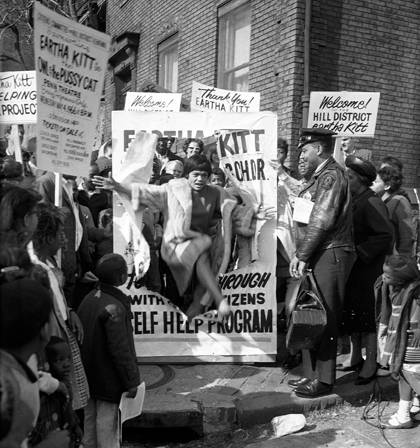 Eartha Kitt atraviesa un cartel para apoyar un Comité de Ciudadanos en el programa de renovación de Hill District, en 1966. Charles Harris