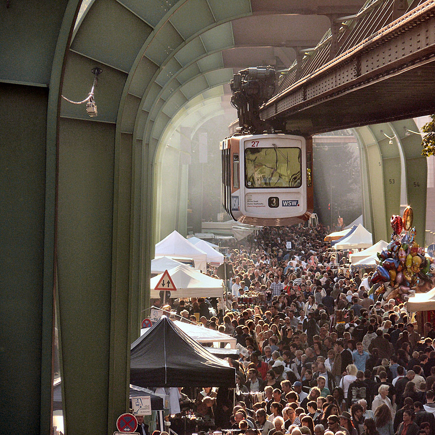 El tren sobre la ciudad sobrevuela un mercadillo callejero. Frizztext